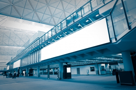 big Blank Billboard in airport with moving blurred passenger, blue tune, shot in hong kong, asiaの写真素材