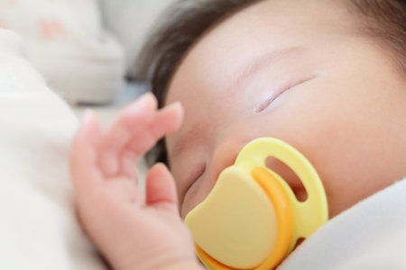 Newborn beautiful baby sleeping with pacifier. Closeup portrait
