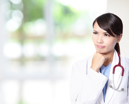 Young doctor woman think with stethoscope with nature green background, model is a asian femaleの写真素材