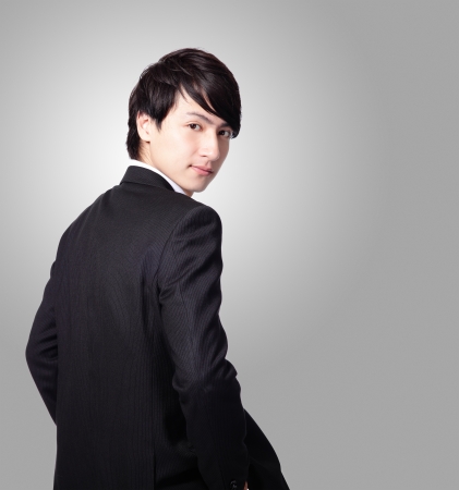 Successful business man smiling face and looking to you with gray background, model is a asian maleの写真素材