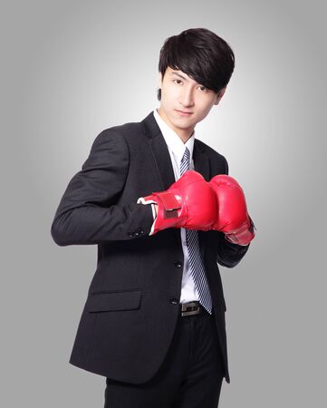 successful businessman smile with boxing gloves isolated on gray background,  Business competition concept, asian modelの写真素材