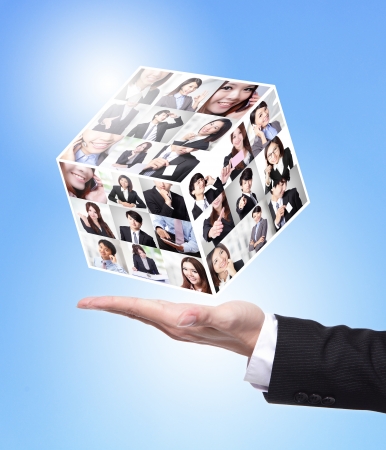 Human Resources concept: business man hand holding a magic cube made by all business people faceの写真素材
