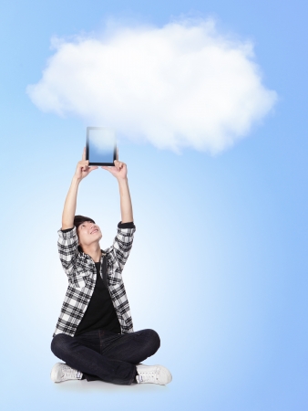 Young man holding tablet pc with cloud computing background, asian modelの写真素材