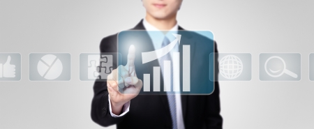 Business man pressing a touch screen button with all kinds of business icon isolated on gray background, asian modelの写真素材