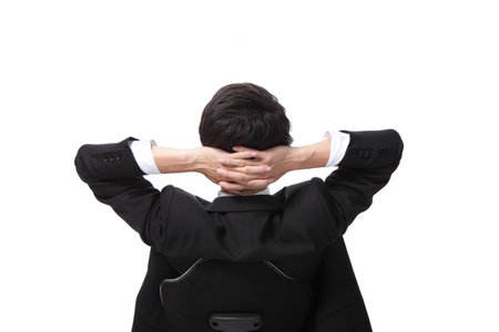 Rear viwe of a relaxed businessman with hands behind his headの写真素材