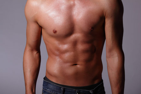 Sexy muscular young man. Isolated on gray background. asian and european mixed blood