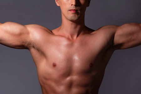 Sexy muscular young man. Isolated on gray background. asian and european mixed blood