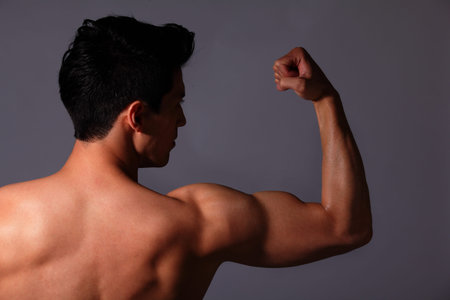 Sexy muscular young man. Isolated on gray background. asian and european mixed blood