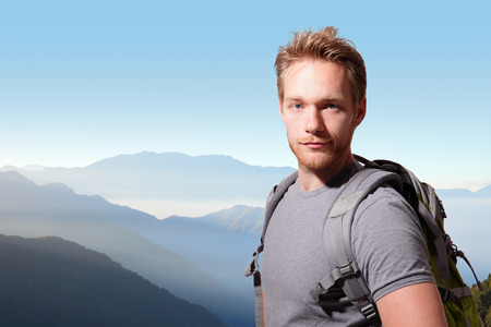 Successful man mountain hiker with backpack on the top of mountains. caucasianの写真素材