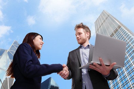 business people shaking hands with city backgroundの写真素材