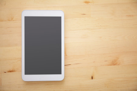 Blank modern digital tablet on a wooden desk. Top view. great for your copy space