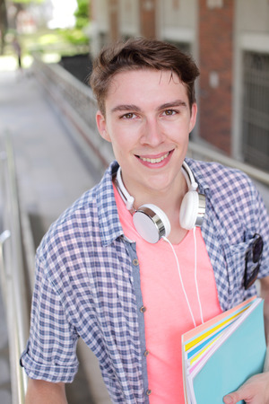 Happy male student holding books smile to you, caucasianの写真素材