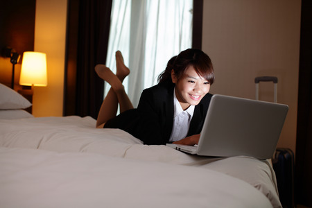 business woman working on bed with laptop in hotel at night. asianの写真素材