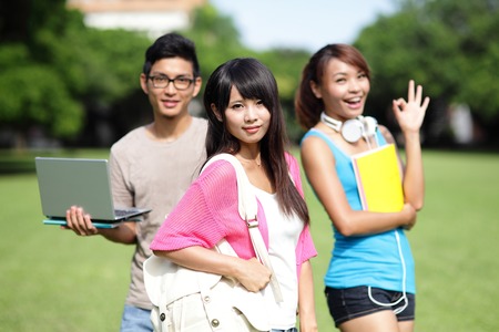 Happy girl College students smile to you on campus lawn, asianの写真素材