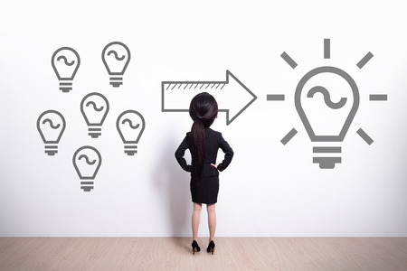 idea and innovation concept - Back view of business woman look light bulb - big head cute womanの写真素材