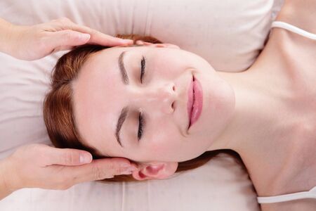 Beautiful young woman enjoy face massage at spa, caucasian beautyの写真素材