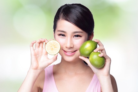Health girl show lemon with smile face, health food concept, asian woman beautyの写真素材