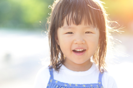 Happy Cute little girl on the meadow in summer day, asianの写真素材