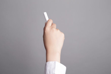 hand hold chalk and writing something on gray background, great for your design or textの写真素材