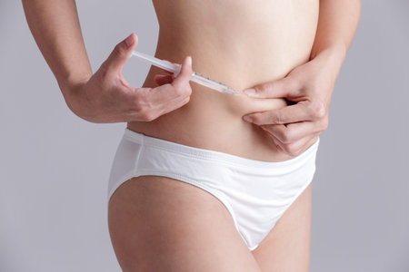 close up of woman inject drugs to prepare for IVF treatment isolated on gray backgroundの写真素材