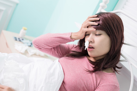 Sick Woman sneezing into Tissue. Flu and Woman Caught Cold.の写真素材