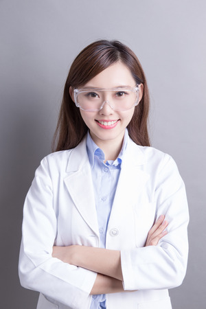 Smiling woman lab technician isolated on gray background, asian