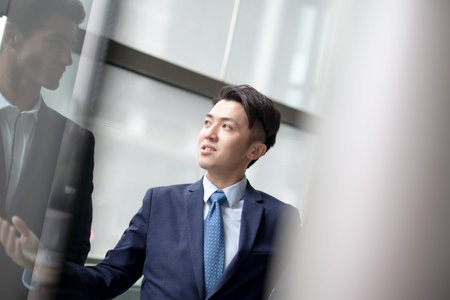 business people group meeting pointing something in front of the office window, asian people,europeanの写真素材