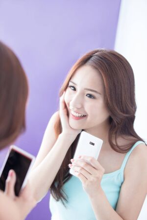 Beautiful smile happy woman smile and take selfie by mirror. asian beautyの写真素材