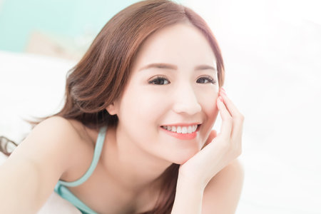Health woman Smile take a selfie and she lying on the bed at home , asian girlの写真素材