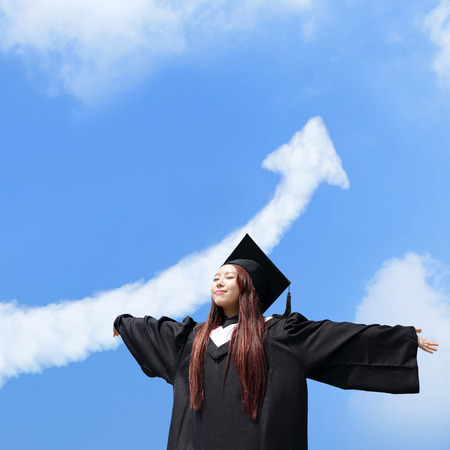happy graduate student girl hug future and feel carefree look up with cloud arrow in the sky, she wear graduation cap and gown ,asianの写真素材