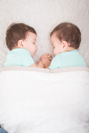 Newborn beautiful baby twins sleeping with pacifier. Closeup portrait, caucasian childの写真素材
