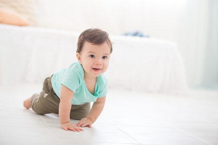crawling baby boy on living room floor and he smile to you, caucasian childの写真素材