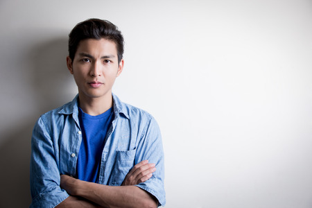 handsome man wear denim shirt and look serious,isolated white background,asianの写真素材