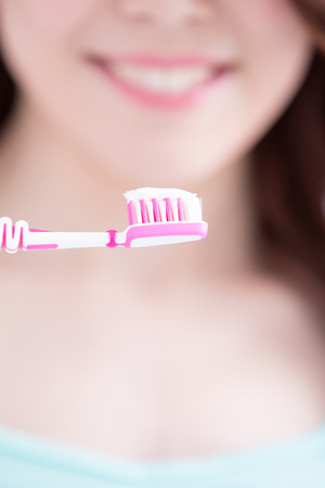 Beautiful young woman with health teeth and charming smile.holding the tooth brush, asian beautyの写真素材