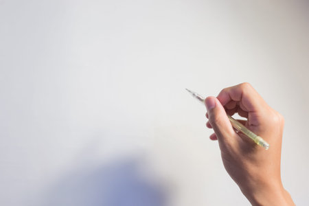 take pencil in the hand with white wallの写真素材