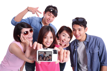 Happy teenagers taking pictures by themselves isolated on white background, asianの写真素材