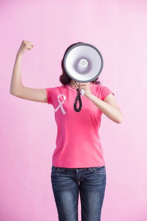 Happy woman hold microphone with pink ribbon , great for prevention breast cancer conceptの写真素材