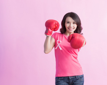 Happy woman hold boxing gloves with pink ribbon , great for prevention breast cancer conceptの写真素材