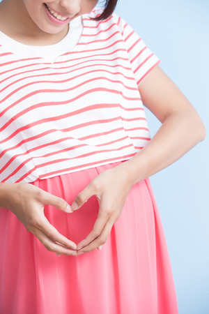 pregnant woman is smile isolated on bluebackground, asianの写真素材