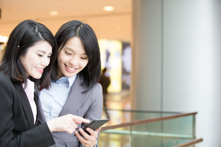 two businesswoman use phone in hong kong, asianの写真素材