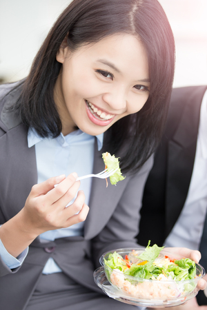 businesswoman eat salad in office in hongkongの写真素材