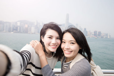 two beauty woman smile happily and selfie in hongkongの写真素材