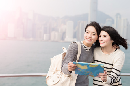 two beauty woman take map and look somewhere in hongkongの写真素材