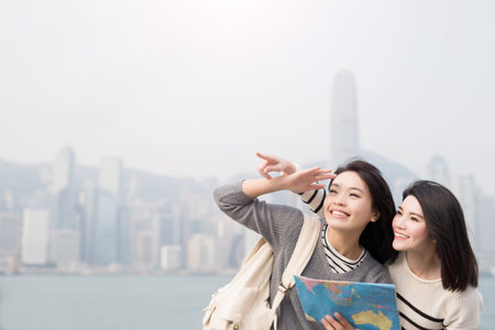 two beauty woman take map and show something in hongkongの写真素材