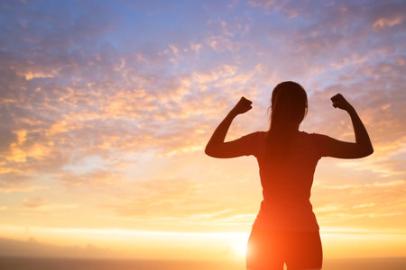 silhouette of sport woman feel free with sunlightの写真素材