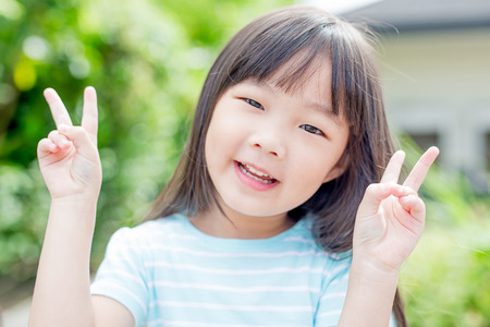 little girl smile happily in the park,asianの写真素材