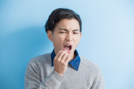 man feel toothache with blue background, asianの写真素材