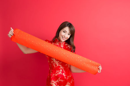 beauty woman wear cheongsam and show couplets with chinese new yearの写真素材