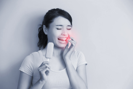 woman have sensitive teeth with ice , asianの写真素材