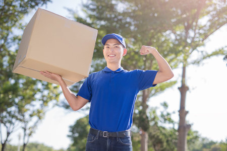 deliveryman hold heavy box and smile, asian